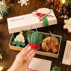 A set of Arenzza Christmas scented candles and Halloween-themed candles arranged in a gift box with festive decorations.