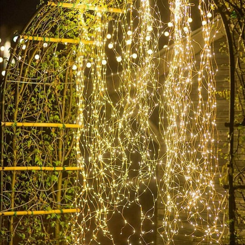 A bunch of waterproof Christmas LED firefly twinkle lights from Arenzza with warm white glowing bulbs for holiday decor.