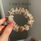 A pair of Arenzza elegant rhinestone mesh hair ties with purple accents, perfect for stylish hair accessories.