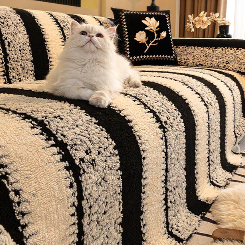 A soft plush non-slip couch cover by Arenzza, in a cozy light beige color, draped over a sofa in a living room setting.