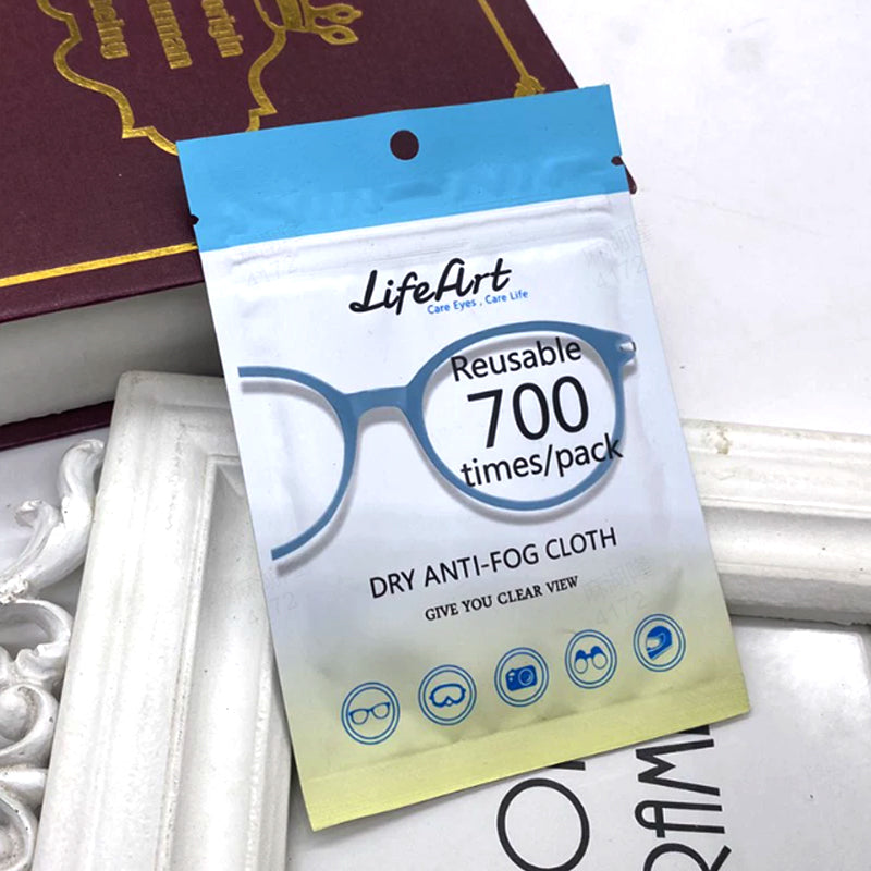 Aarenzza reusable anti-fog cloth for glasses, showing a person cleaning clear lenses with the soft cloth in a kitchen setting.