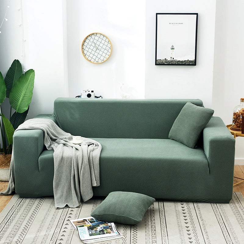Arenzza Jacquard knitted stretch sofa cover in a stylish design, fitting snugly over a sofa for a fresh, cozy look.