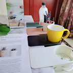 Arenzza clip-on desk cup holder attached to a desk edge, holding a coffee mug in a home office or kitchen setting.