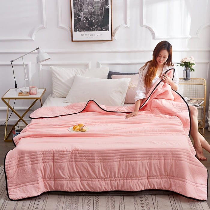 Arenzza ice cooling calming blanket in a cozy bedroom setting, showcasing its lightweight, breathable fabric for summer sleep comfort.