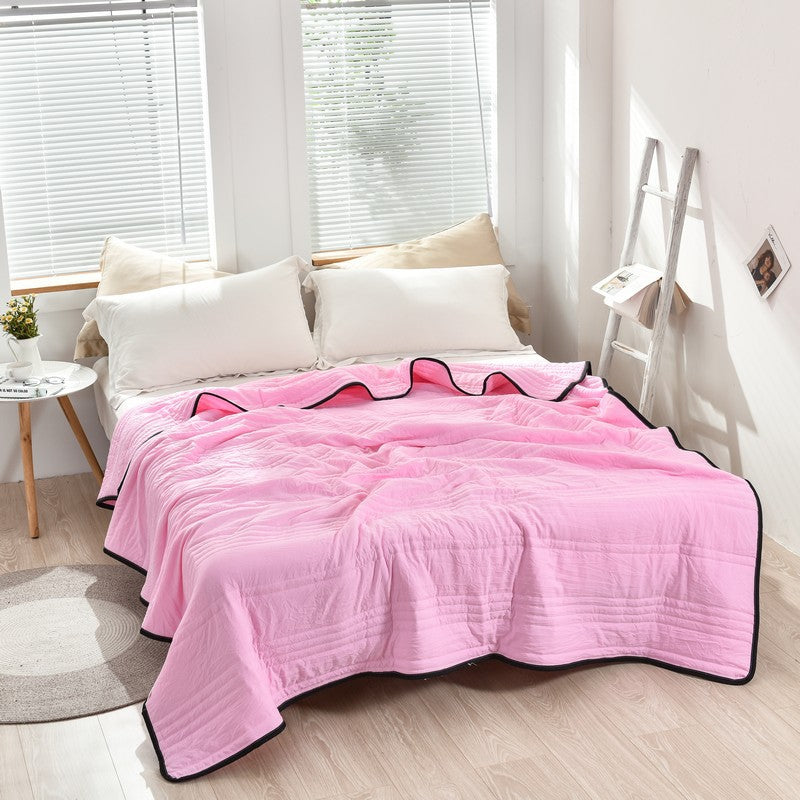 Arenzza ice cooling calming blanket on a bed, showcasing its soft, lightweight fabric designed for summer sleep comfort.