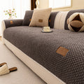 Arenzza thickened non-slip washable sofa cover draped over a sofa, showcasing its textured fabric and secure fit for houseware and kitchen use.