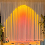 Arenzza LED Sunset Projection Lamp casting warm sunset hues, ideal for photography, parties, and home decor in bedroom or living space.