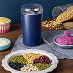 Arenzza portable grinder for beans and spices, compact kitchen appliance with stainless steel grinding chamber and black plastic body.