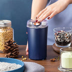 Arenzza portable coffee and spice grinder with stainless steel body and adjustable grind settings on a kitchen countertop.