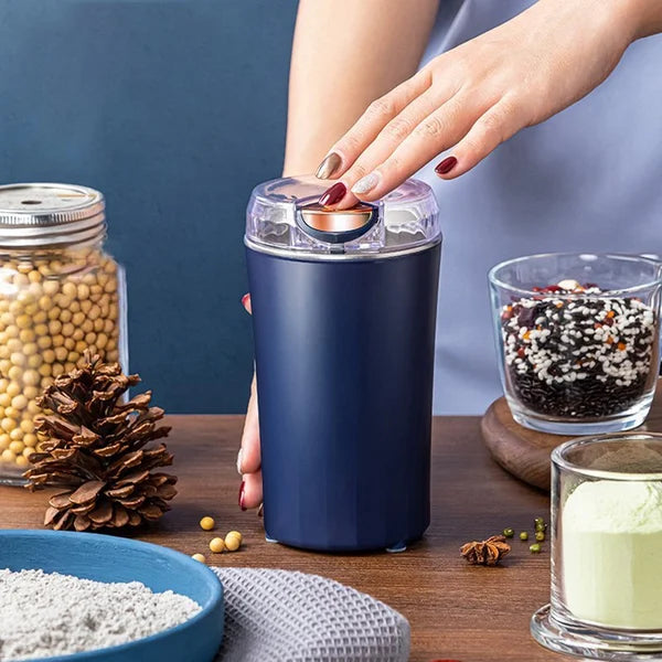 Arenzza portable coffee and spice grinder with stainless steel body and adjustable grind settings on a kitchen countertop.