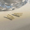 A pair of elegant leaf-shaped stud earrings by Arenzza, featuring intricate jewelry accessories design in a close-up shot.