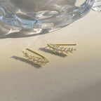 A pair of elegant leaf-shaped stud earrings by Arenzza, featuring intricate jewelry accessories design in a close-up shot.