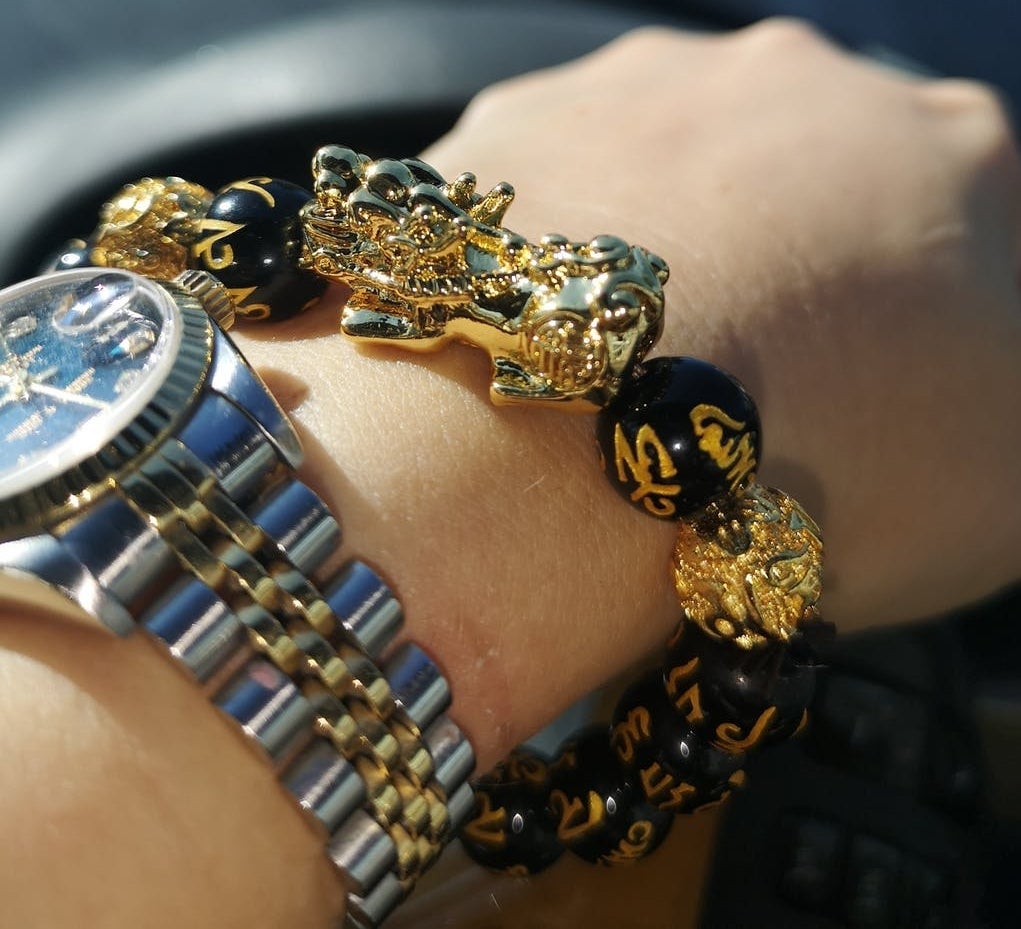 Arenzza FengShui bracelet for wealth and happiness, featuring colorful beads and symbolic charms, worn on a wrist.