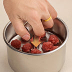 Aarenza stainless steel meatball mould for kitchen use, showing multiple round meatballs formed in the mould.