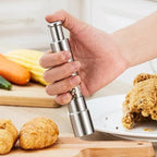 Arenzza professional kitchen salt, pepper, and spice grinder with refillable glass chambers on a countertop.