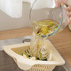 Arenzza magnetic suction space-saving corner sink strainer in a kitchen setting with a black finish and compact design.