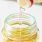 Arenzza leak-proof glass oil bottle with spray and pour spout, ideal for kitchen use, showcasing its sleek design and secure lid.