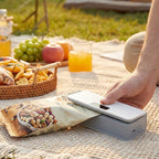 Arenzza rechargeable 2-in-1 mini bag sealer with cutter for kitchen use, shown sealing plastic bags with built-in cutting edge.