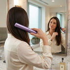 A woman using the Arenzza EasyStraight™ hair straightener to style her hair in a modern lifestyle setting.