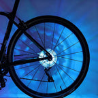 Arenzza LED cycling wheel hub light installed on a bike wheel for night riding, showcasing vibrant illumination and outdoor setting.