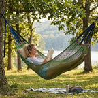 Arenzza upgraded camping hammock with ropes, shown hanging between trees in a natural outdoor setting for camping and outdoor relaxation.