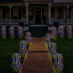 Aarenza LuminaGlow™ solar firework garden lights in multi-color, waterproof starburst stake lamps illuminating a garden path at night.