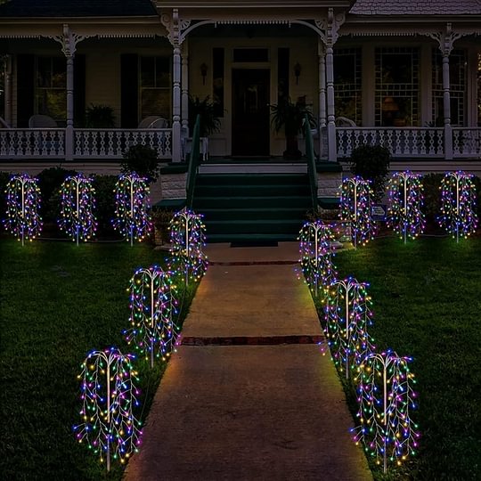 Aarenza LuminaGlow™ solar firework garden lights in multi-color, waterproof starburst stake lamps illuminating a garden path at night.