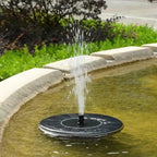 Arenzza solar powered fountain in a garden, showing water flowing from a garden tool-style fountain head in a lush outdoor setting.