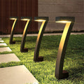 Aarenza waterproof solar pathway lights in garden setting, illuminating a stone walkway with bright LED lights for outdoor lighting.