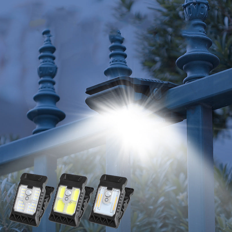 Arenzza outdoor solar clip light with motion sensor, mounted on a garden wall, illuminating the area at dusk.