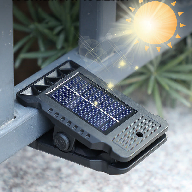 Arenzza outdoor solar clip light with motion sensor, mounted on garden wall, illuminating the area at night.