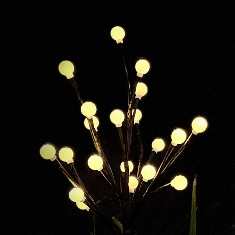 Arenzza solar-powered LED garden stake light with tree branch design illuminating outdoor garden or pathway at dusk.