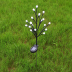 Arenzza solar-powered LED garden stake light with tree branch design illuminating a garden at night