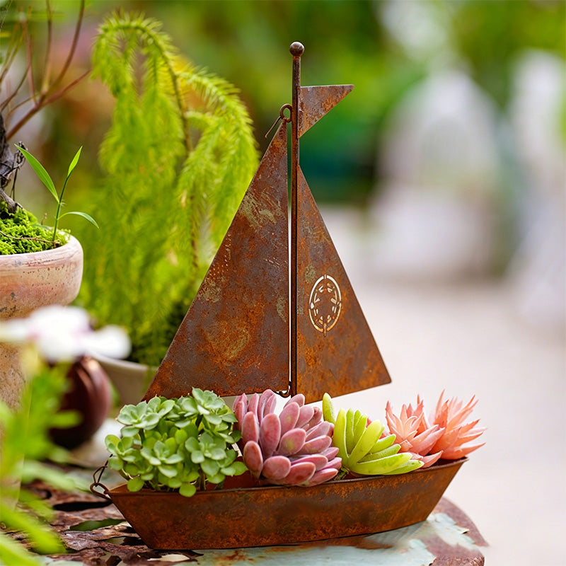 Rustic metal sailboat planter by Arenzza, weather-resistant, perfect for succulents, herbs, or flowers, garden or shelf decor.