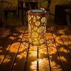 Aarenza hanging solar shadow lantern with hollow design, outdoor garden tool for decorative lighting, mounted on a hook in a garden setting.