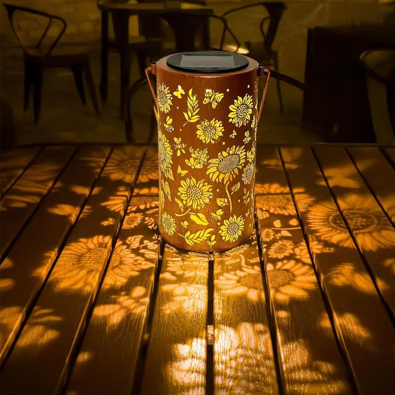 Aarenza hanging solar shadow lantern with hollow design, outdoor garden tool for decorative lighting, mounted on a hook in a garden setting.