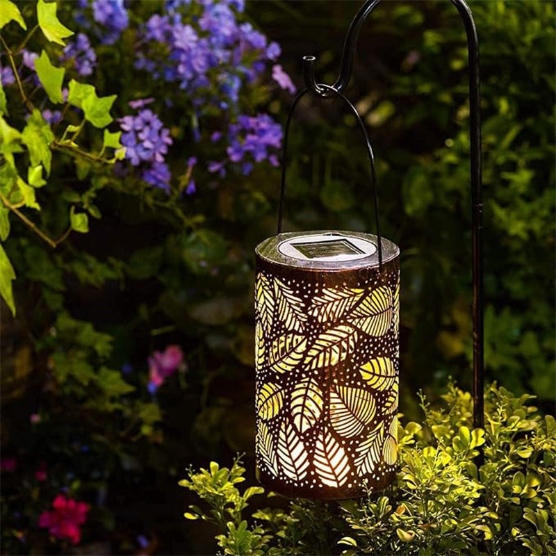 Aarenza Hanging Solar Shadow Lantern with hollow design, outdoor garden tools and lighting, illuminated at dusk.