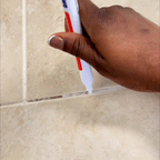 Arenzza Tile Marker Grout Pen in black, used for sealing and touching up grout lines, shown in a garden or tile setting.