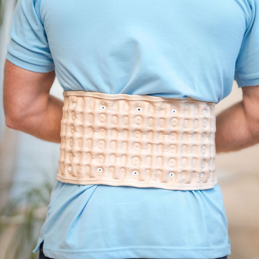 A person wearing the Therava™ Press Belt by Aurenza Shop, demonstrating its adjustable support around the waist.